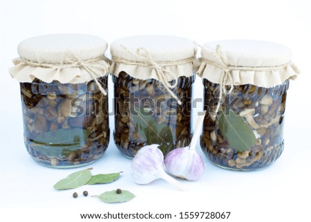 Pickled mushrooms in a jar on a white background. Stocks of mushrooms for the winter. Horizontally. Copy space.