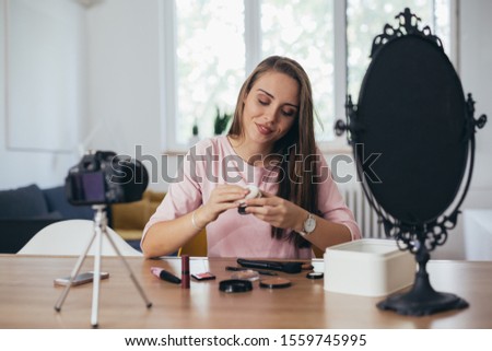 woman makeup vlogger at her home, presenting new line of cosmetic products
