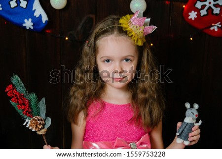 Little girl with christmas toy and tree branch. Child with handmade on wooden background. Happy new year concept.