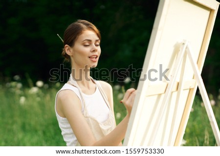 woman artist paints a picture on canvas