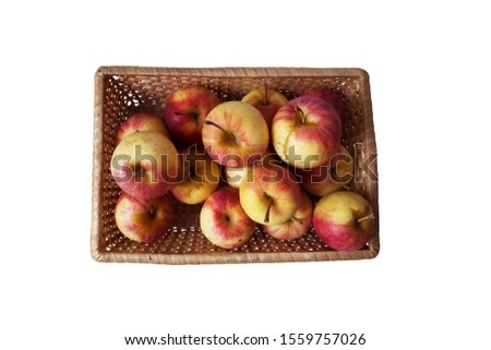 Bright red apples in a basket woven on a white background.