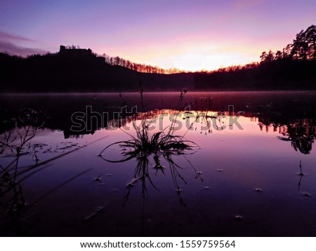 Beautiful purple sunset and mirror reflection in pond