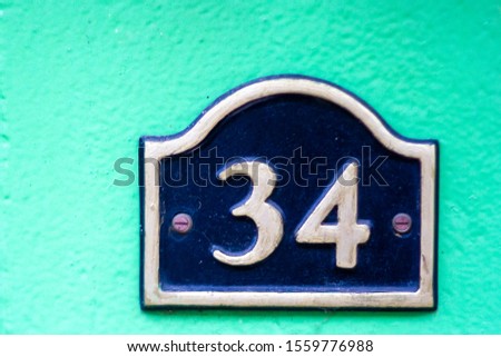 House number 34 on a lime green wall