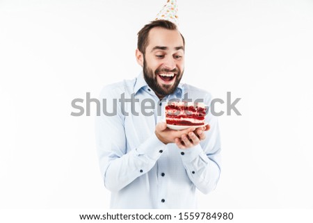 Image of cheerful party man smiling and holding birthday cake with candle isolated over white background