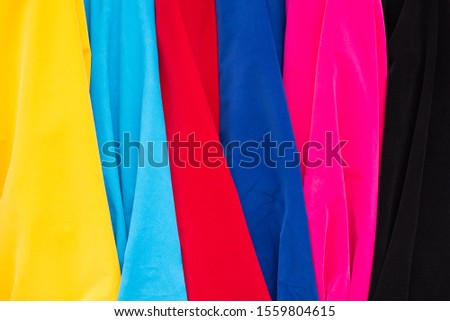 Traditional fabric store with stacks of colorful textiles at market stall.