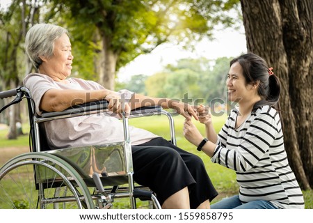 Asian care assistant or daughter is massaging palm and fingers of senior mother feel numb,elderly woman having injured hands suffer from hand numbness,arthritis,beriberi or peripheral neuropathies
