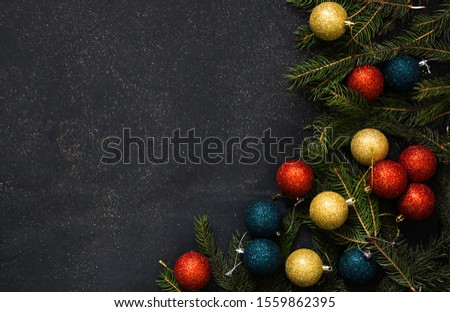 A frame of green fir and Christmas toys on a black background with empty space. Flat lay.
Top view