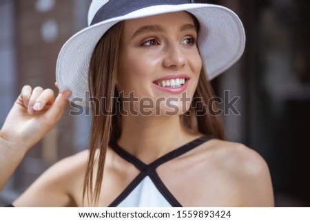 Close up picture of a beautiful young woman standing in the street and smiling