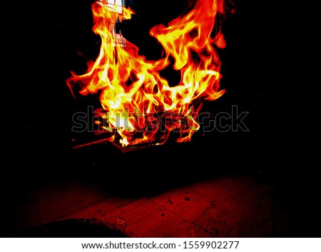 Fire flames occurring from wood in the dark room. fire flame in shape of dragon.