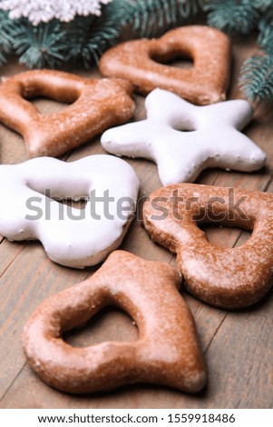 Gingerbread cookies and Christmas decor on a brown wooden background.