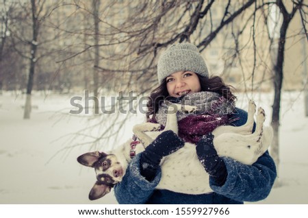 Girl playing with dog under the snow