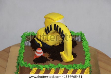 Edible Alloy Excavator Truck Car Vehicles and pile of soil with traffic cone on the square chocolate cake.