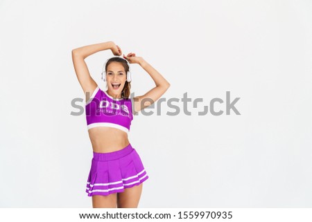 Photo of happy positive cheerleader woman isolated over white wall background listening music with headphones.