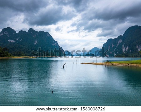 Isolated island or tree in lake, Aerial photos from drones on beautiful lake in mountain at Ratchaprapha Dam and Cheow Lan Lake, Khao Sok, Thailand.