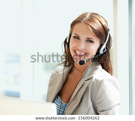 businesswoman talking on the phone while working on her computer at the office Royalty-Free Stock Photo #156004262