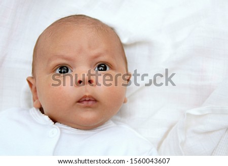 baby wrapped up in blanket looking with big blue eyes just been cared for after having a good sleep in bed with mother stock photograph stock photo