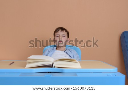 Young Caucasian boy studying himself to sleep.
