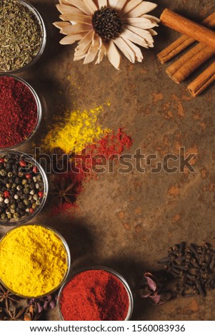 Different types of Spices in a bowl on a stone background. The view from the top. Place for text. 