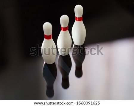Reflections of mini bowling pins on a reflective surface