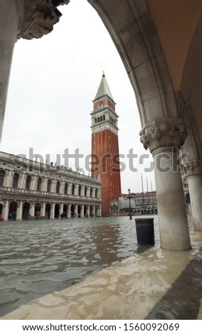 Arcade frame of Ducal Palace in Venice in Italy and the bell Tower of Saint Mark during the flood