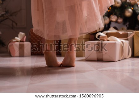 feet of a child next to a Christmas tree, close-up