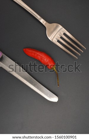red chili pepper ingredient wth fork and knife metal 