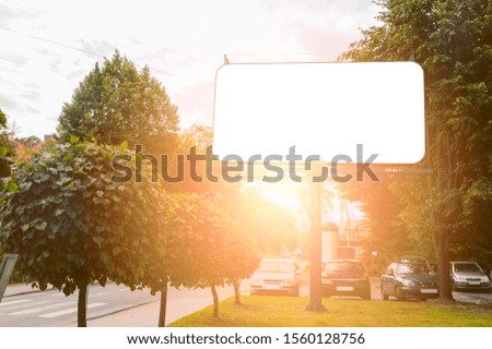 Advertising billboard mockup on the street. Summer sunny sunset in the city