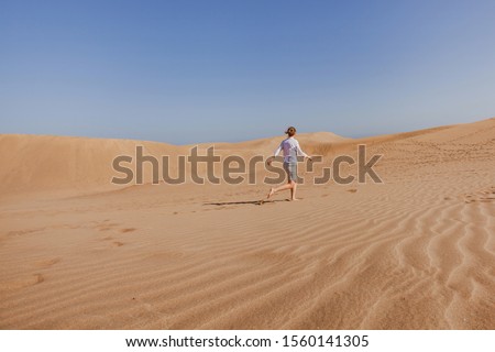 woman tourist running in sand dunes