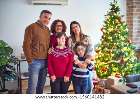 Beautiful family smiling happy and confident. Standing and posing around christmas treeat home