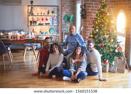 Beautiful family smiling happy and confident. Sitting on the floor and posing with tree celebrating Christmas at home