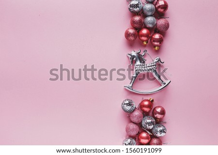 Border of Small pink and silver Christmas balls and silver horse on pink background