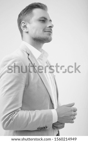 Portrait of a handsome blonde man model in a fashion gray suit isolated on white background in studio