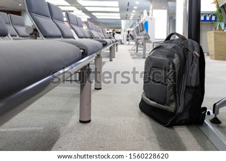Unattended cabin backpack abandoned on the floor at the boarding waiting hall of an airport. Royalty-Free Stock Photo #1560228620