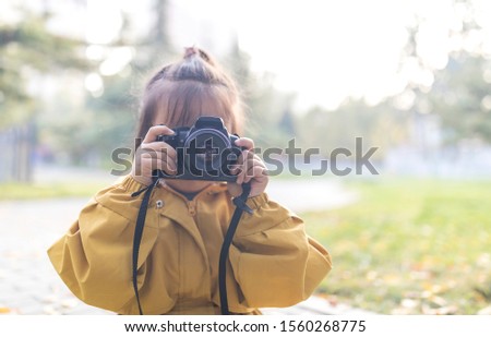 Lovely asian girls learn to take photos in the park in autumn