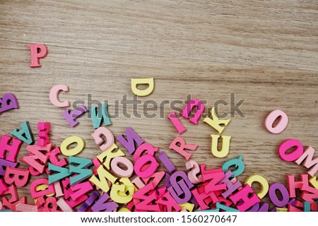 random colorful letterpress alphabet with space copy top view on wooden background