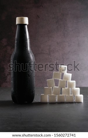 Sugar cube stack like pyramid and carbonated drink on dark background. Copy space for text.