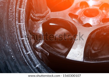 A close-up of tire fitting a car wheel: separating old tires from molten faces using a tire changer. Work at the tire workshop