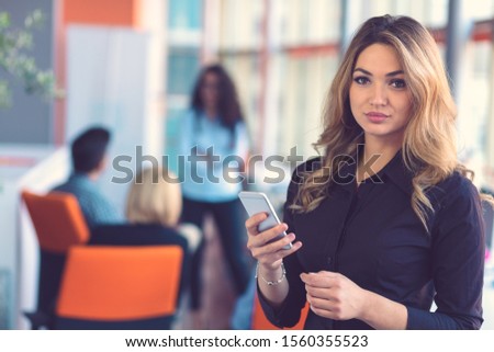Woman speaking on mobile phone in front of team
