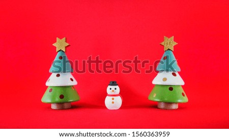 Snowman and Christmas tree decoration on the​ red texture background 