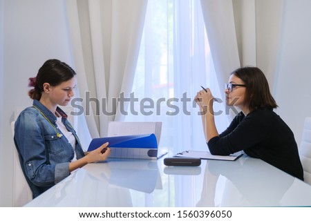 Female teacher teaching teenage girl individually, private lessons, help with exams Royalty-Free Stock Photo #1560396050