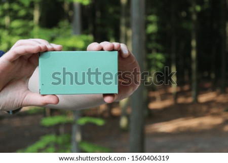 Two hands are holding a signboard for labeling in nature