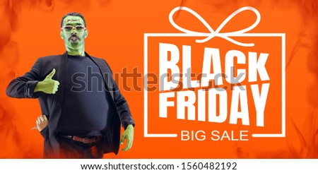 Man as a zombie with green skin and thumb up on orange fire background, black friday. Scary characters, business, advertising. Black friday, cyber monday, sales, finance, money online purchases