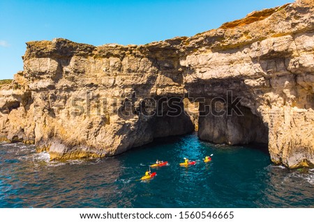 Group of kayakers under cave. Comino island. Drone landscape. Europe. Malta  Royalty-Free Stock Photo #1560546665
