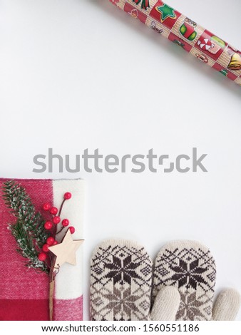 Christmas decor. Mittens, scarf, gift, sprig of spruce on a white background. Christmas picture. Wallpaper.Flatlay