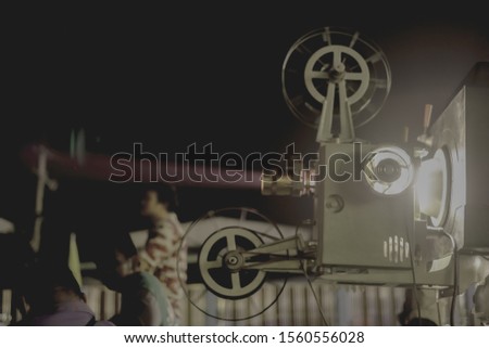 blurred focus of movie projector and beam light for vintage feeling in the outdoor theater street festival retro style of rural entertainment with dark night background and copy space