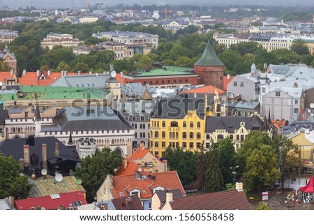 Aerial view of Latvian War Museum, (before it was called Powder Tower) and Riga Old Town from Saint Peter church on cloudy, foggy and rainy day, Riga, Latvia. Soft selective focus