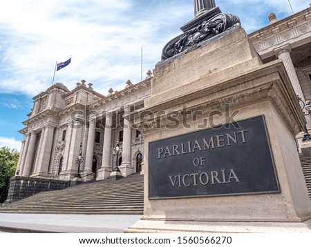 Facade of the Parliament House of the state of Victoria in Melbourne, Australia. Stairways and a flag of Australia, blue sky during a day of spring. Royalty-Free Stock Photo #1560566270