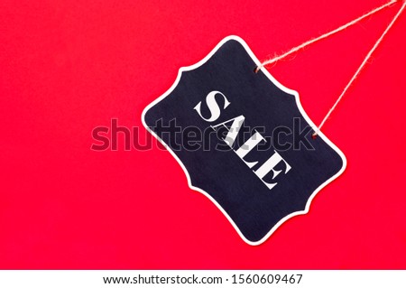 Sale sign on black tag template  isolated on contrast red background .Shopping  concept. Top view.