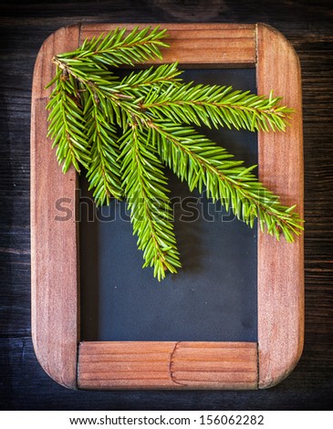 Christmas composition in vintage style. Spruce branch on the chalkboard 