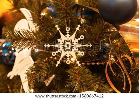 Christmas tree with silver bauble ornaments. Decorated Christmas tree closeup. Balls and illuminated garland with flashlights. New Year baubles macro photo with bokeh. Winter holiday light decoration